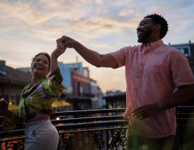 A couple dances on a French Quarter balcony