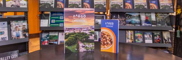 Fargo visitor guide and dining guide in front of brochure racks