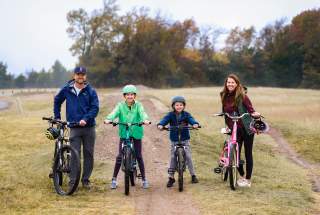 Family of four on bicycles in a field