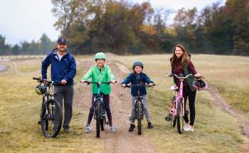 Family of four on bicycles in a field
