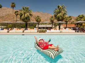 Santa relaxing on a floaty in the pool in Palm Springs