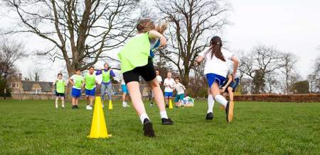 children running sports drills in a park