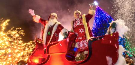 Father Christmas and Mrs Claus waving from a sleigh