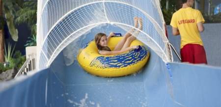 Girl in a rubber ring on a water slide,