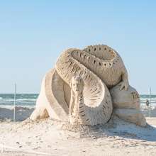 Sand sculpture of a sea serpent-type monster with a human woman head