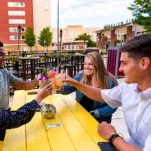 Young adults enjoying drinks at the Sidecar outdoor bar in downtown Fort Wayne.