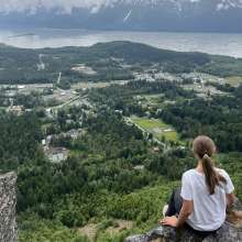 View of town of Haines from mountain top, girl over looking