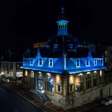 a historic, spired building with a blue under-lit rooftop