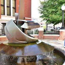 lady and son in a courtyard looking at a sculpted fountain