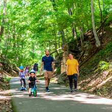 family with children on bikes walk the Clarksville Greenway