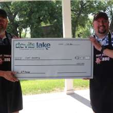 Two men holding a check for second place in Ribfest 2024.