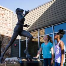 two girls admire the Wilma Rudolph statue