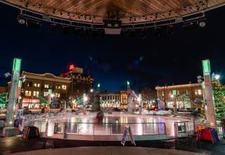 Ice skating rink at night in Main Street Square in downtown rapid city surrounded by lights and historic buildings