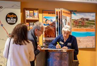 Visit Rapid City staff member helping visitors with area directions at the downtown rapid city visitor center