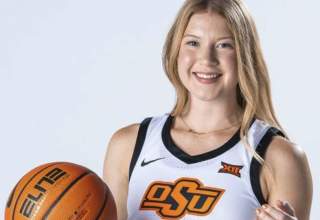 A studio shot of Haleigh Timmer, in her white Oklahoma State basketball jersey while holding a basketball in her right hand.