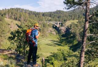 Hiker at the canyon overlook in front of beaver creek bridge in wind cave national park