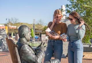 two visitors listening to the audio tour of the city of presidents in downtown rapid city