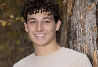 A senior portrait of Owen Johnson, dressed in a tan t-shirt.