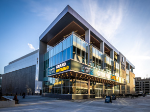 Modern concert venue with a glass facade and large marquee reading “Grand Opening” outside Landmark Credit Union Live in Milwaukee, photographed at sunset with people walking nearby.