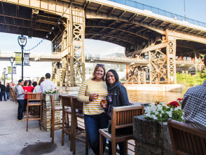 two friends smiling on riverwalk by Lakefront Brewery