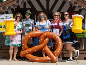 5 people with inflatable pretzel and beer props in German attire.