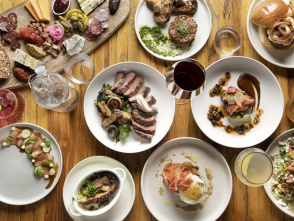 a wide array of food laid out artfully on a wooden table and shot from a birds eye view