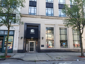 Street view of a beige stone building with tall windows and two trees on the sidewalk. The entrance has a black awning with a white “G” logo and the word “GOODKIND” above the door, along with the address number 333.