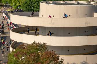 A wide shot of bicyclists ride down the round ramp at the Monona Terrace during IRONMAN Wisconsin