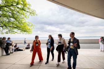 Meeting attendees walking behind Monona Terrace with Lake Monona behind them