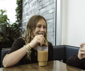 Two kids drinking from a cafe.
