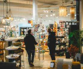 Two people walking through Flying Fish and admiring the store.