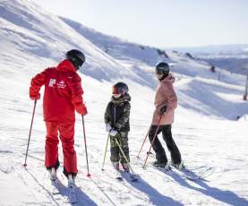 Mother and son having a ski lesson on a snowy mountain