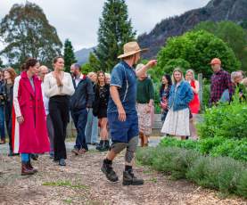 A group of people on a tour through a big vegetable garden