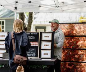 Women purchasing local artwork at the Arrowtown Farmers Market