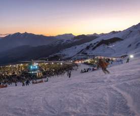 People skiing down mountain during sunset