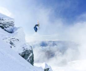 Person doing backflip over rocks at Treble Cone