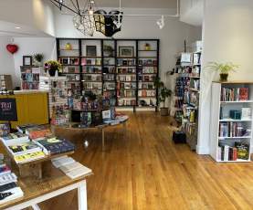 Bookstore layout showing books on shelves and tables.