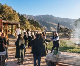 A group of people networking and having fun in an outdoor venue with mountains in the background