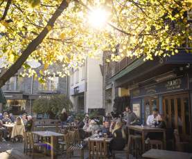 Groups of people dining alfresco at a pub on the waterfront in Queenstown