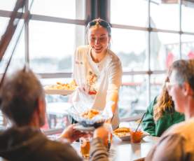 A server handing out plates of food.