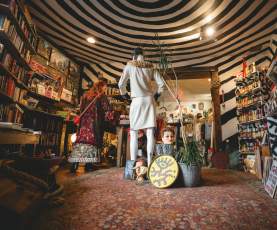 A collection of vintage clothes, decor, and books.
