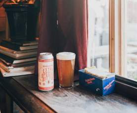 Two beers on a window ledge.