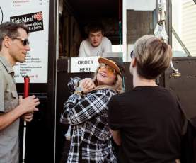 Three people ordering food from a food truck.