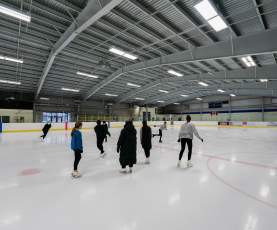 A group of people skating on an ice rink