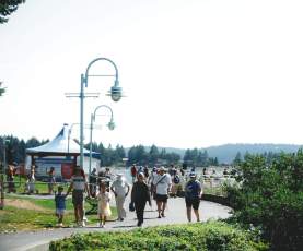 People walking on a path by the ocean.