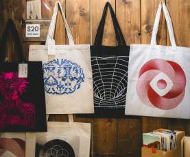 A wall of hanging bags and art pieces