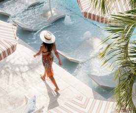 A woman walks by the pool at the Garden District Hotel in New Orleans