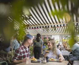 A couple sat at a table enjoying cocktails and brunch at Yonder cafe in Queenstown