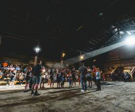 Group of people getting ready to perform a drum in front of a large audience.