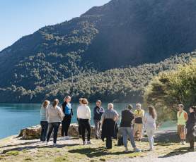 Group of people in front of a lake with mountains at the background